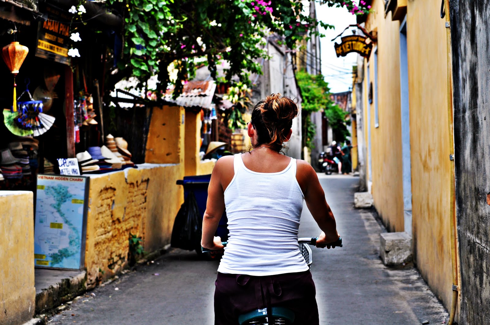 A narrow lane in the old town of Hoi An lined with shuttered yellow buildings