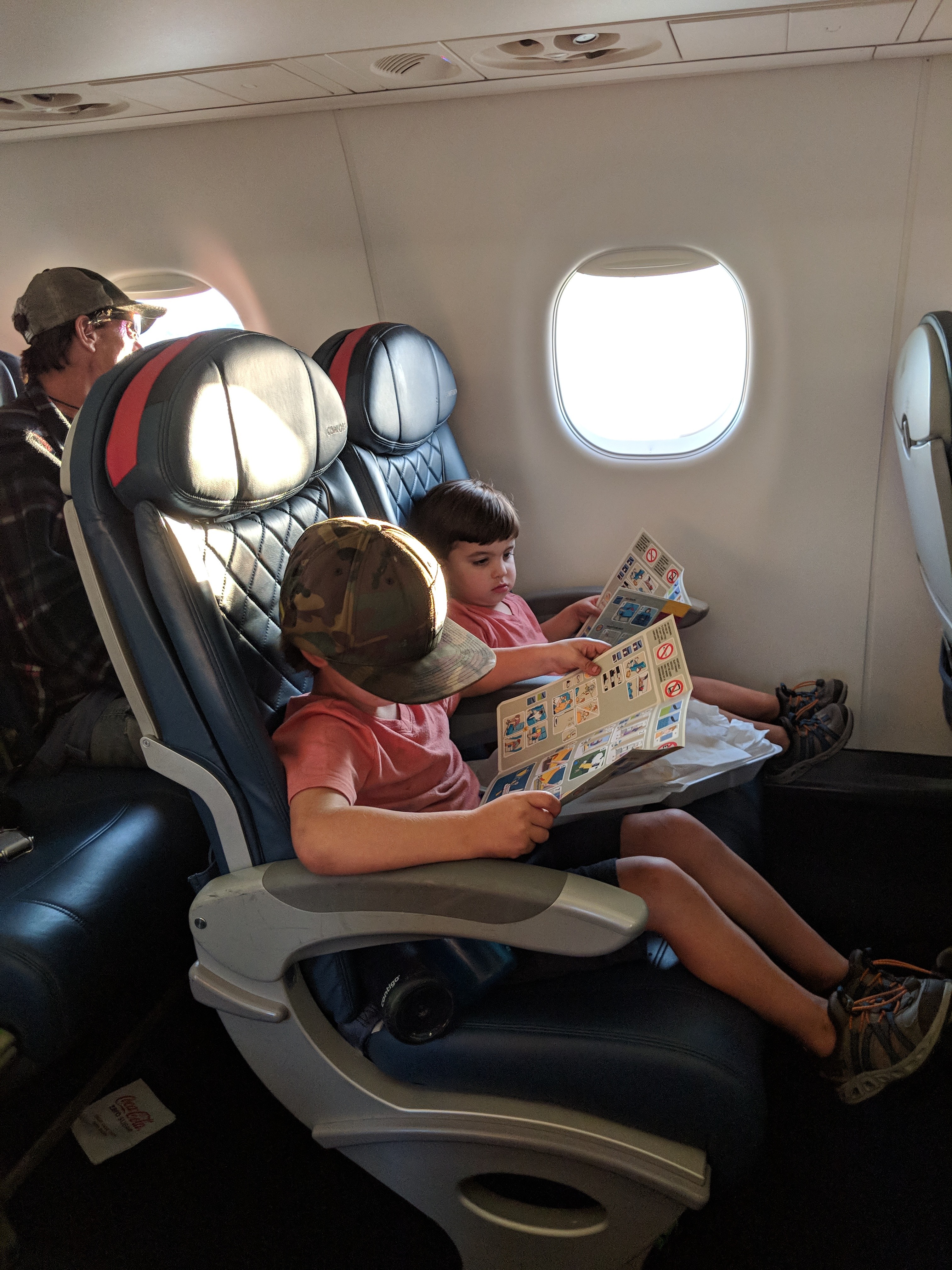 One of the Damiano children reading in an aircraft seat by the window