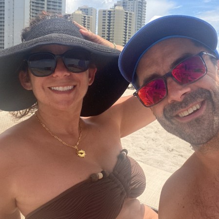 Nicole and Adam smiling on Miami Beach the day their house went under contract — two people who chose one life and are living every single bit of it.