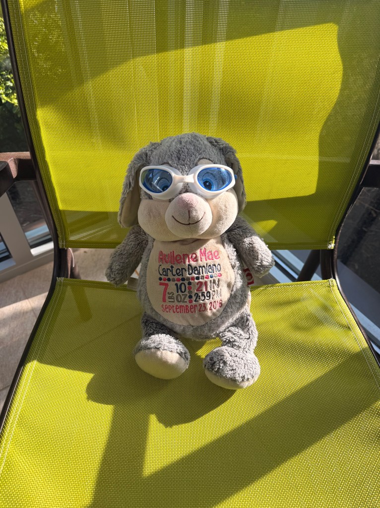 Bun Bun wearing tiny swim goggles relaxing by the indoor pool at Springhill Suites Lenexa Kansas during her extended hotel stay.