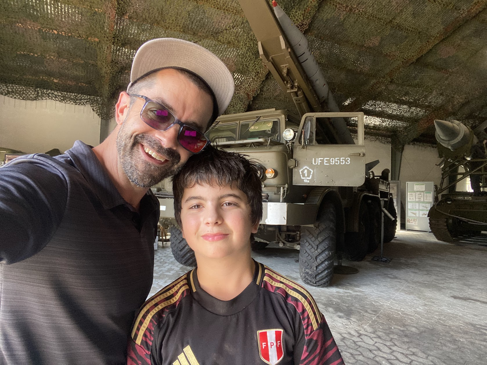 Adam and Jake taking a photo together in front of a row of military vehicles at Panzermuseum East in Denmark