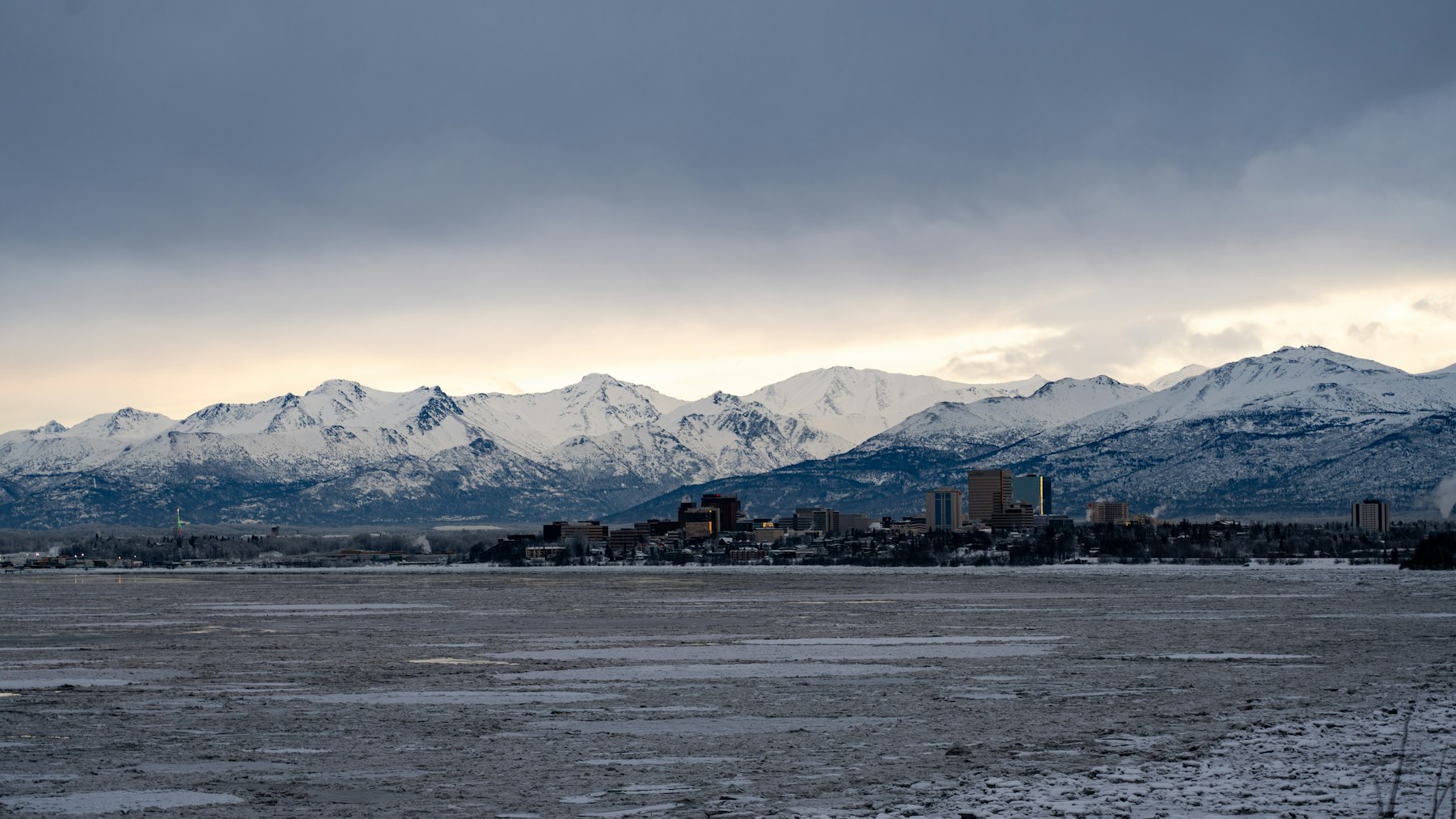 The Anchorage Alaska skyline seen across Cook Inlet with the Chugach mountains behind
