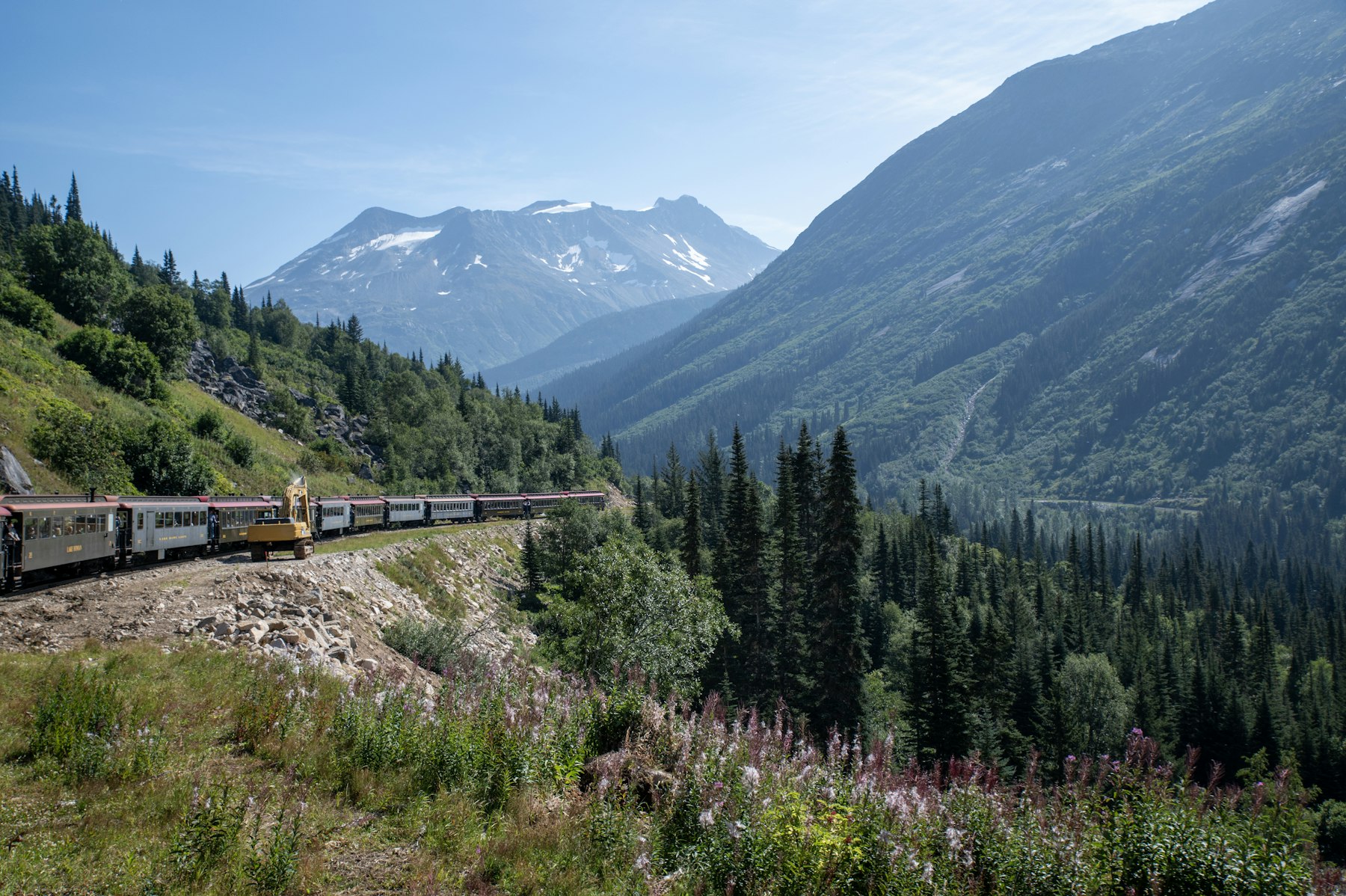 A White Pass and Yukon Route train climbing a green mountainside above Skagway Alaska