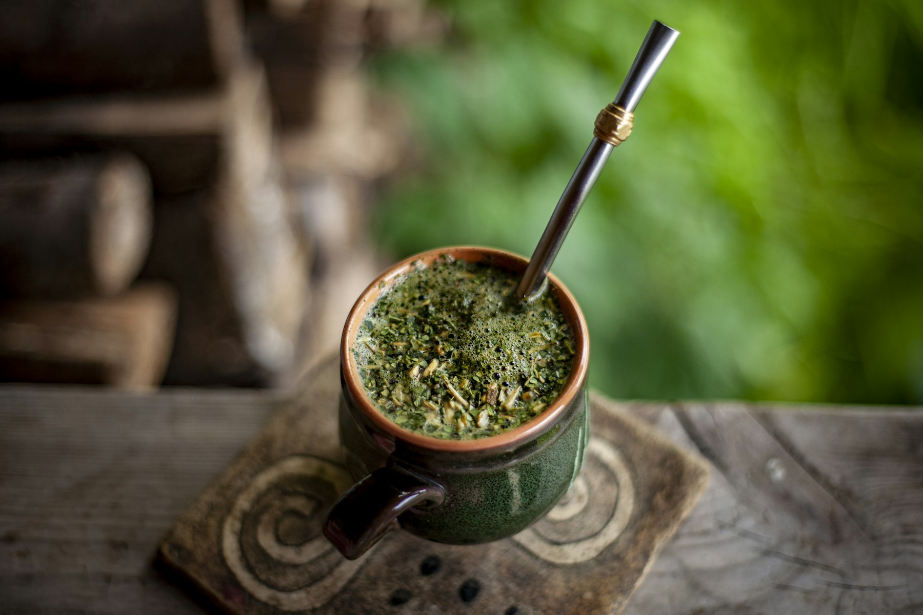 A yerba mate gourd filled with loose leaf and a metal bombilla straw