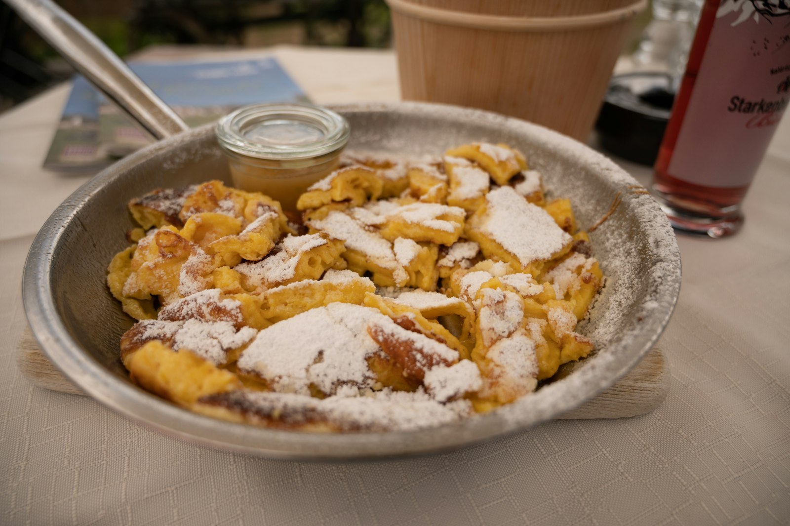 Torn shredded pancake pieces dusted with powdered sugar in a pan