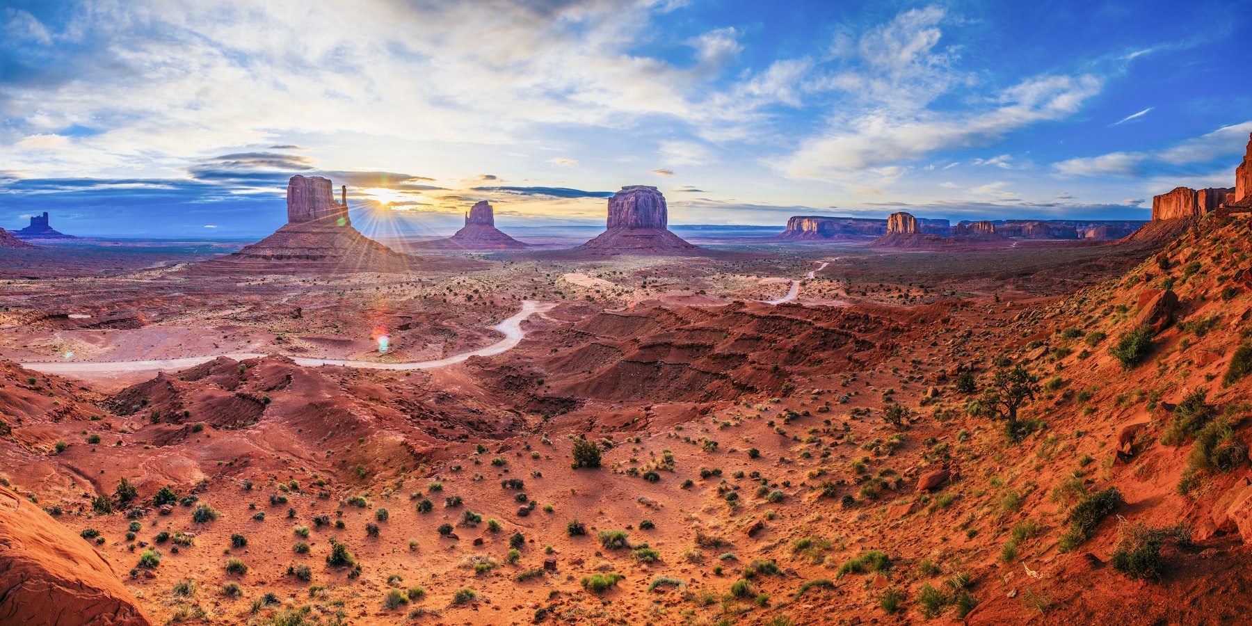 Sunrise over the buttes and the desert road at Monument Valley