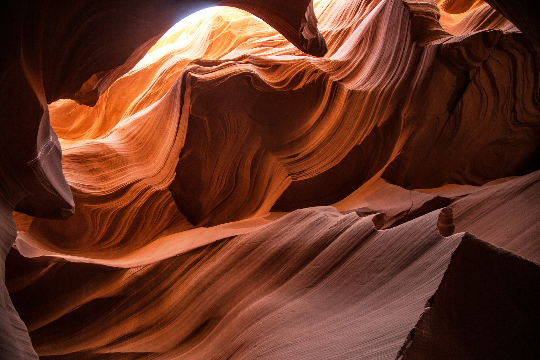 Sunlight falling on the swirled sandstone walls inside Antelope Canyon