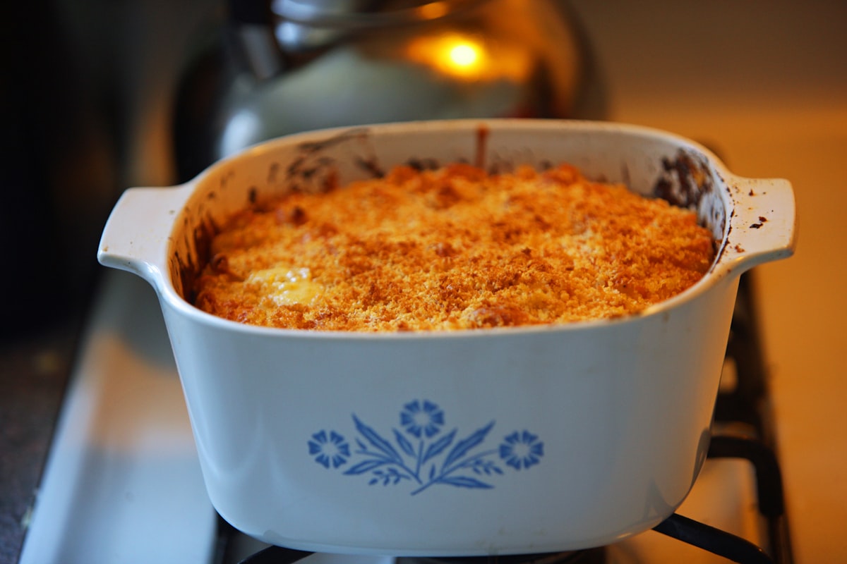 A baked macaroni cheese with a browned crust in a round casserole dish