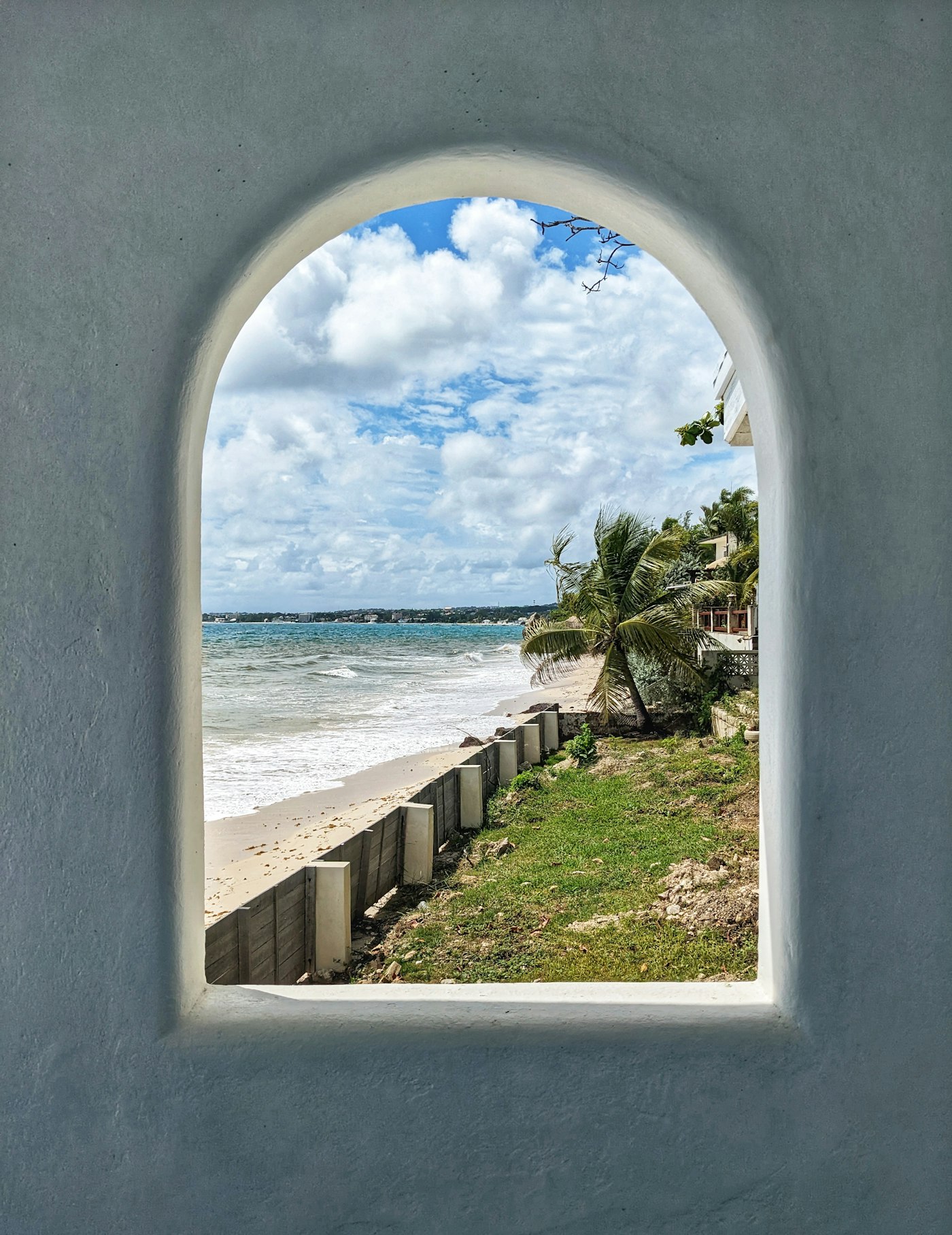 The sea seen from a shuttered window on Enterprise Beach Road at Oistins in Barbados