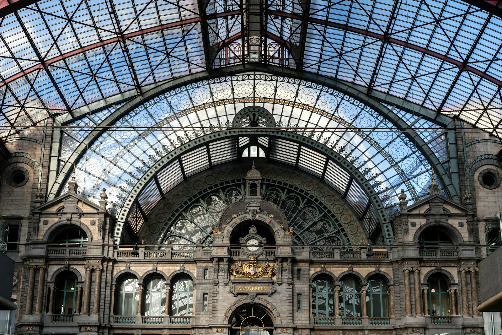 The vaulted stone and glass concourse of Antwerpen-Centraal railway station under its arched roof