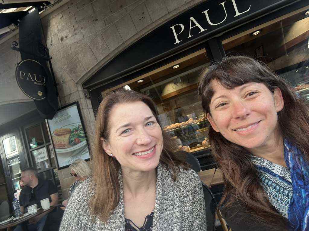 Nicole and a friend outside a bakery on a Brussels street