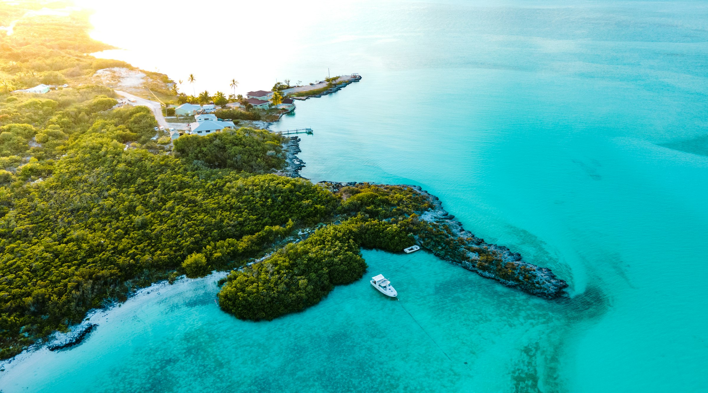A low green island meeting turquoise water in the Exumas