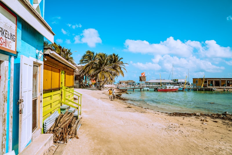 A sandy street of wooden buildings beside the water on Ambergris Caye, Belize