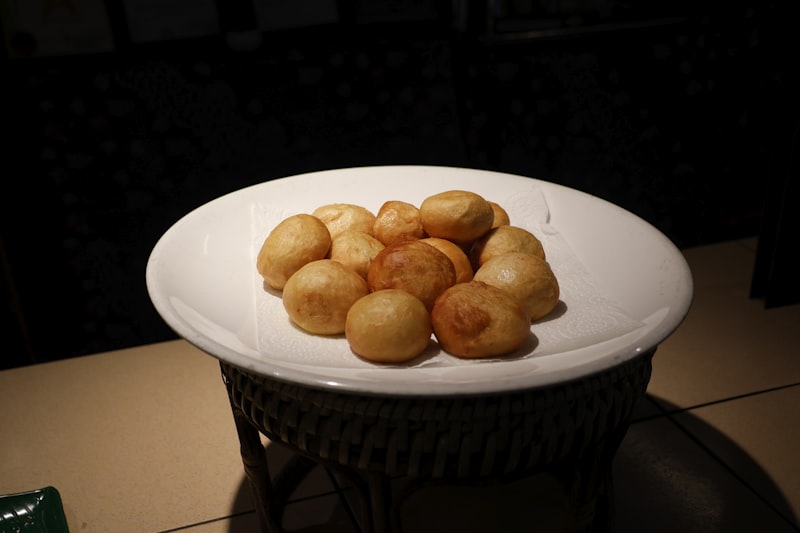 Small golden brown fried dough balls on a white dish