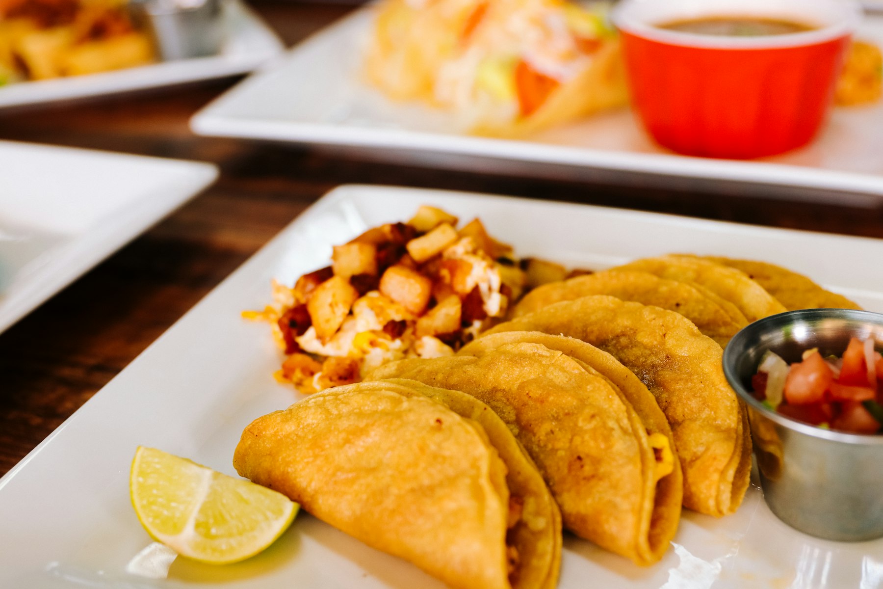 A plate of Chilean empanadas with lemon and salsa on the side