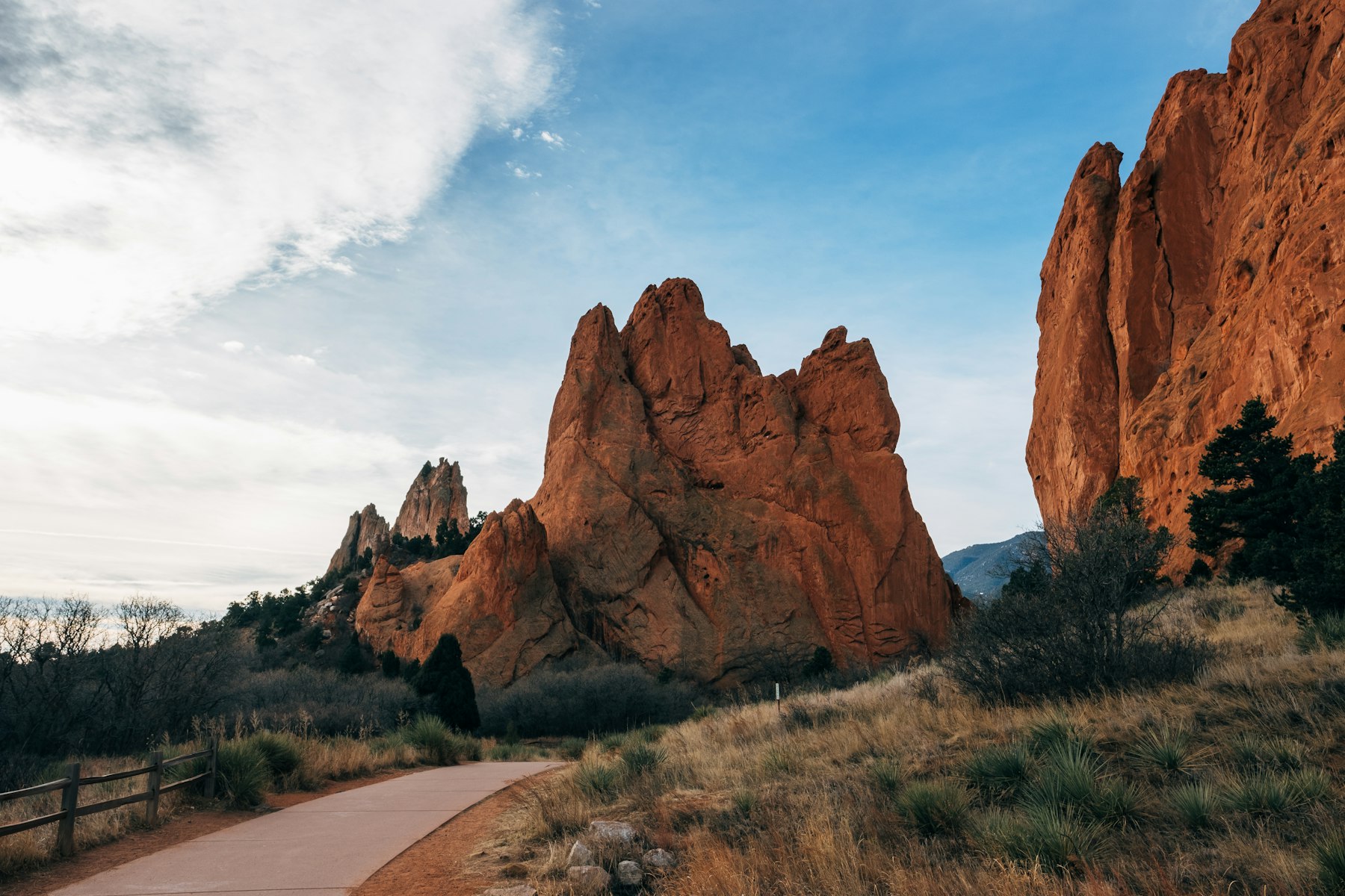 Red sandstone fins rising beside a paved path at Garden of the Gods Colorado Springs