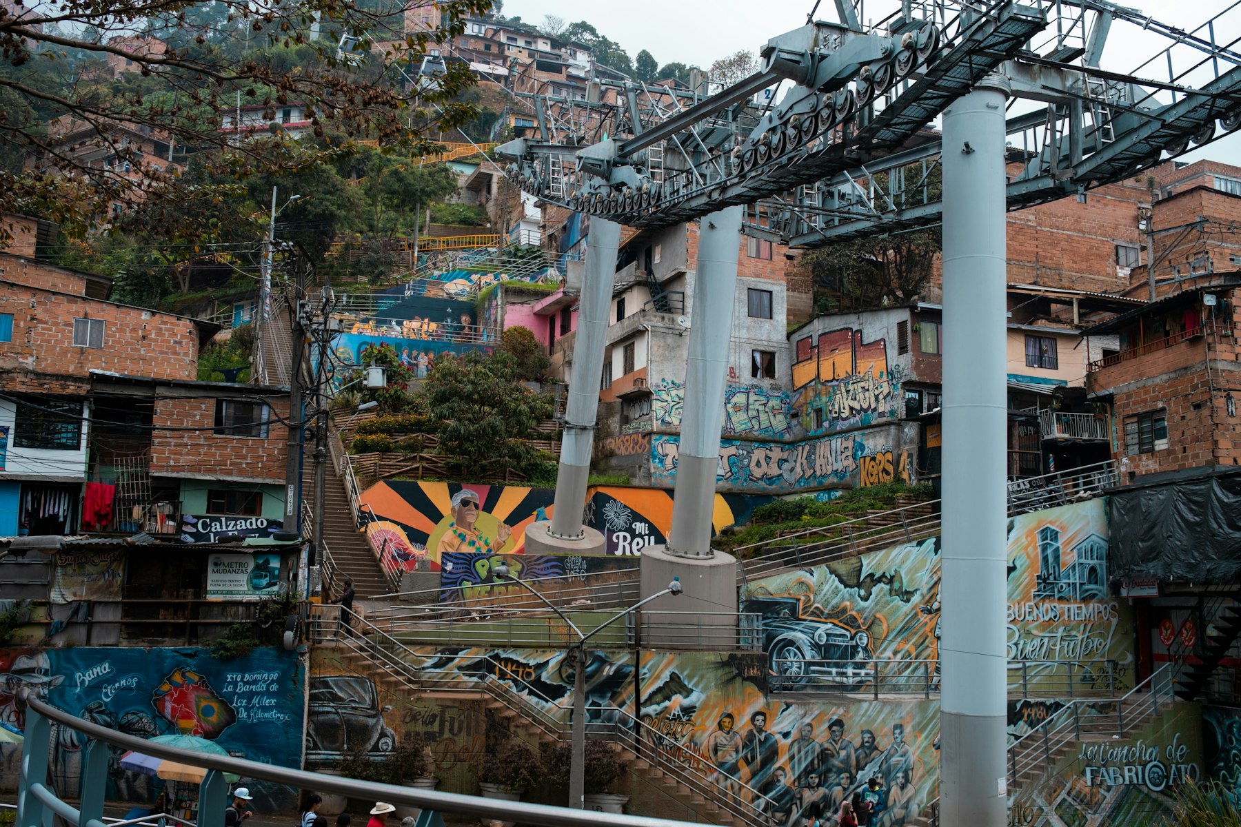Murals and outdoor escalators climbing the hillside of Comuna 13 in Medellin Colombia