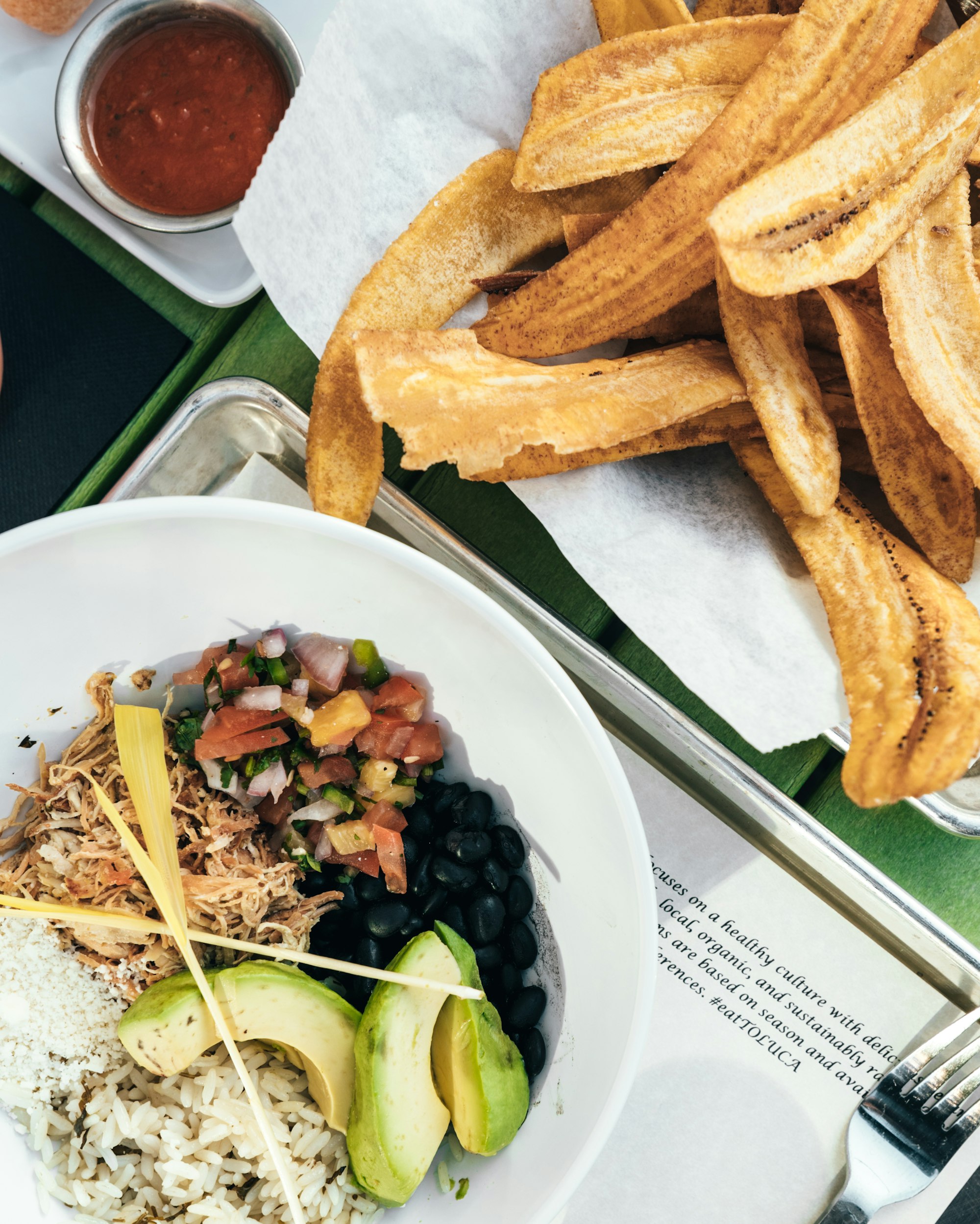 A casado plate of rice black beans salad and fried plantain