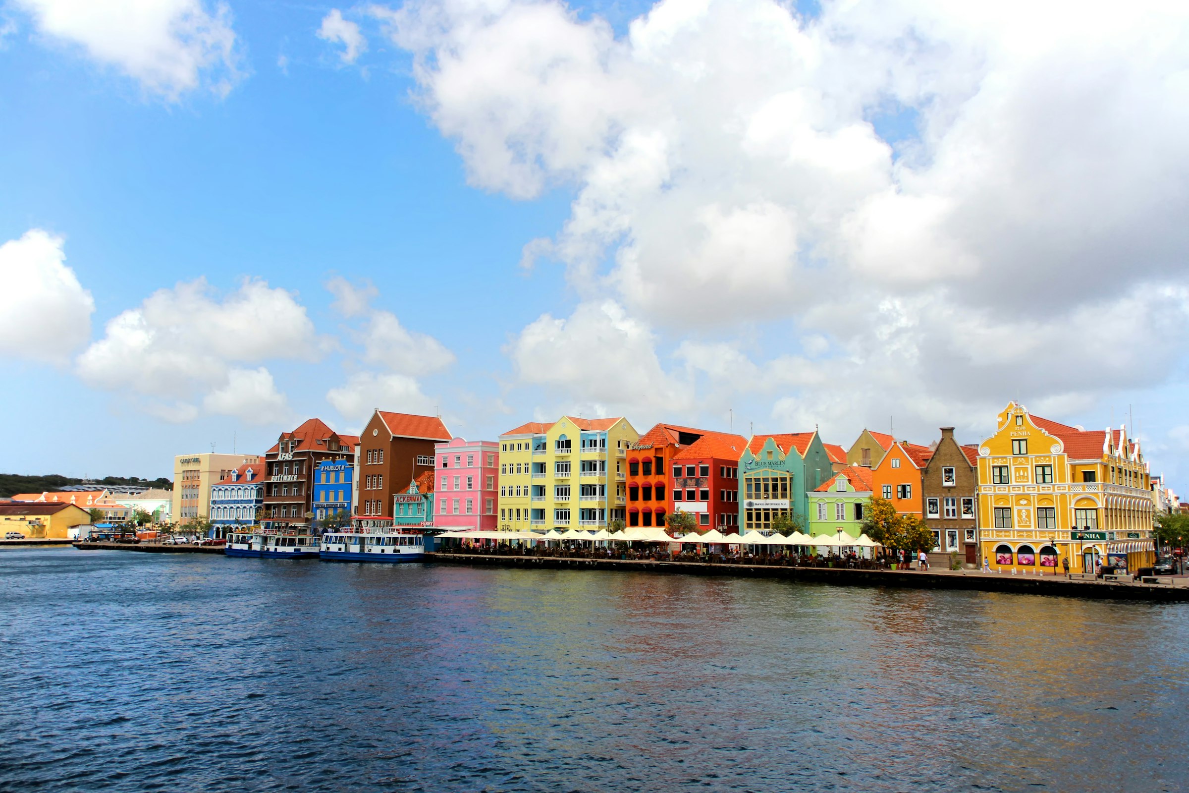 A row of tall painted Dutch buildings along the waterfront at Willemstad, Curacao