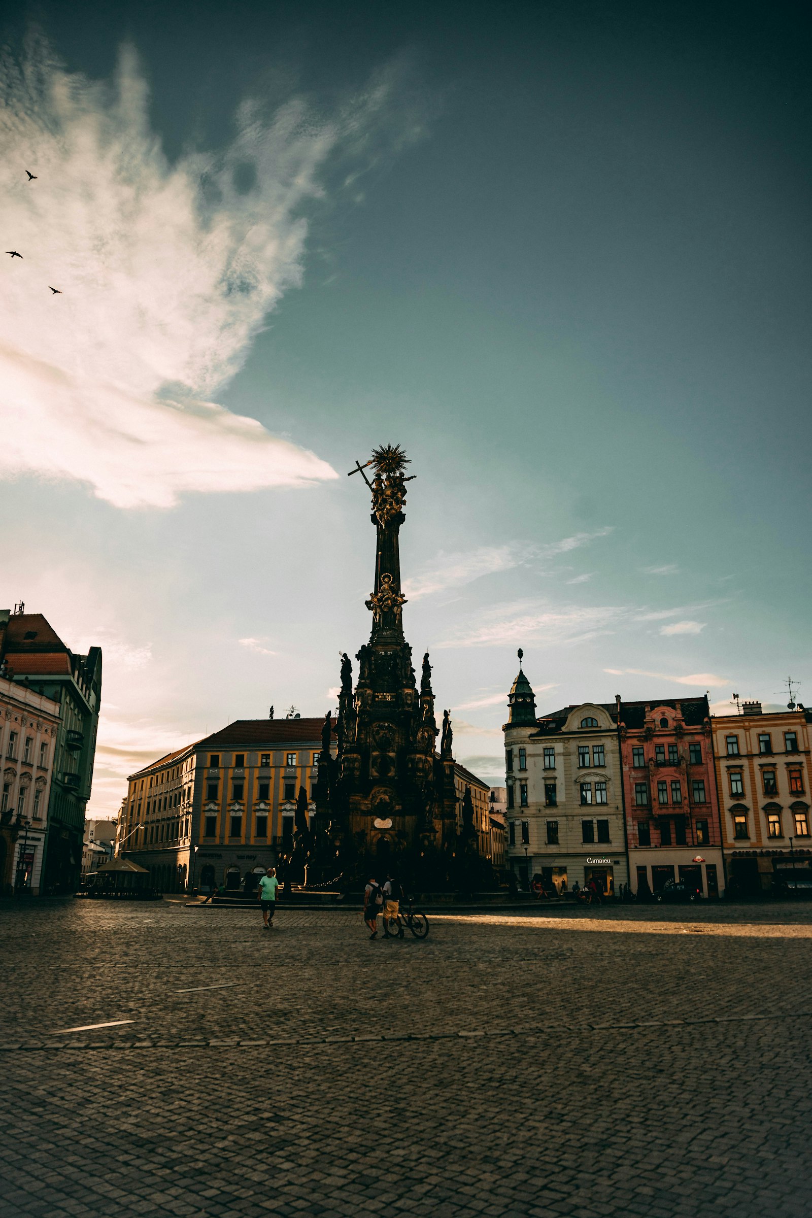 The Holy Trinity Column standing in the empty main square of Olomouc at dawn
