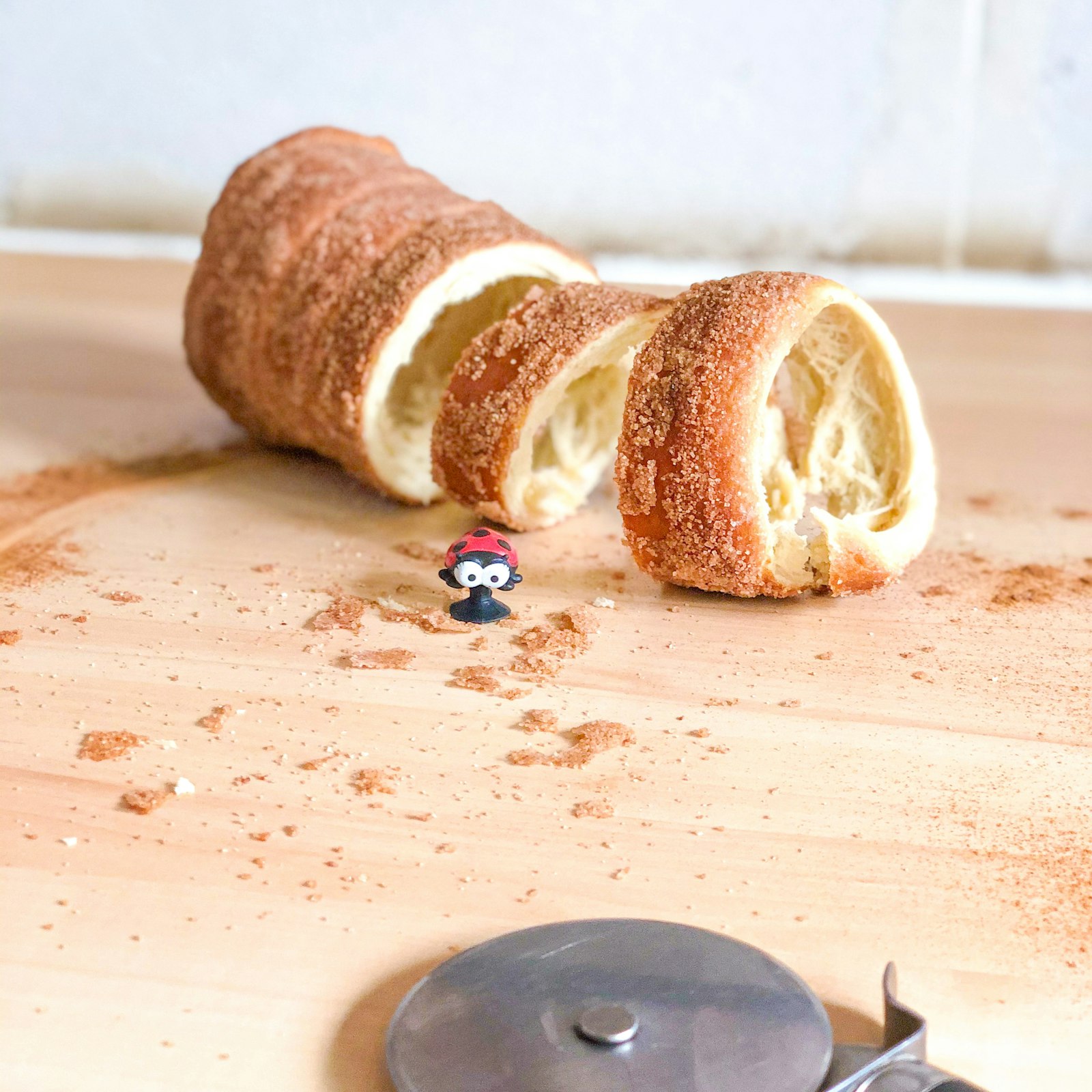 A trdelnik chimney cake pastry rolled in sugar on a wooden board