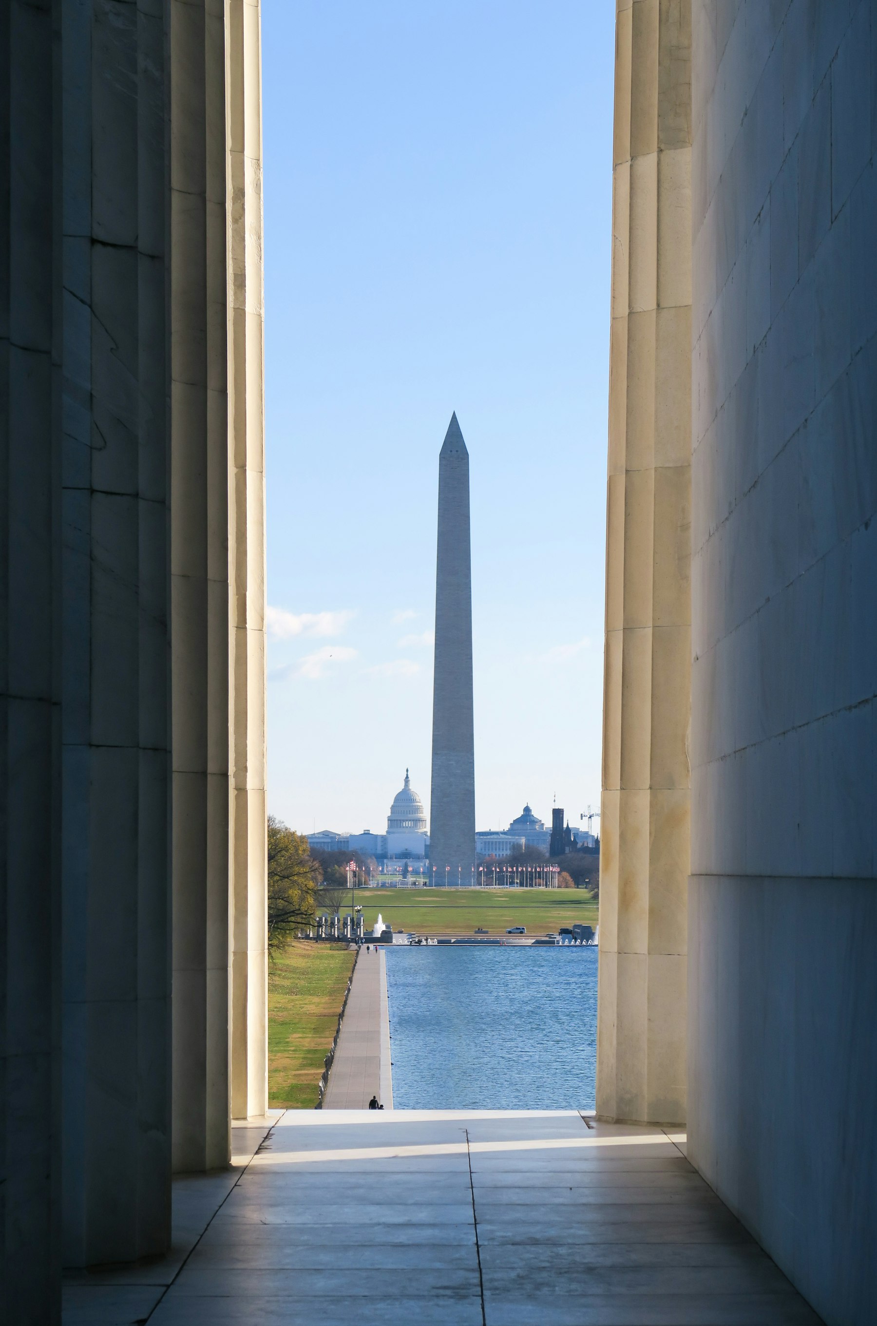 The Washington Monument framed between two marble columns of the Lincoln Memorial