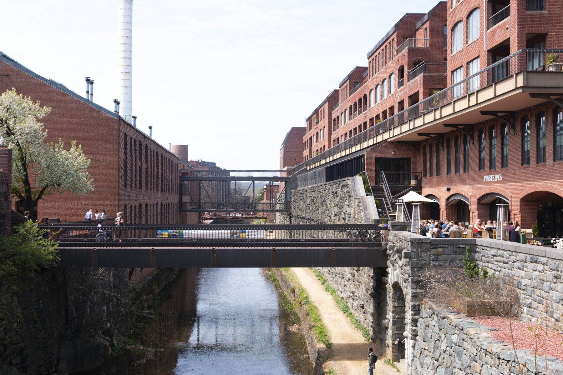 Old brick warehouses and a footbridge over the C and O Canal towpath in Georgetown