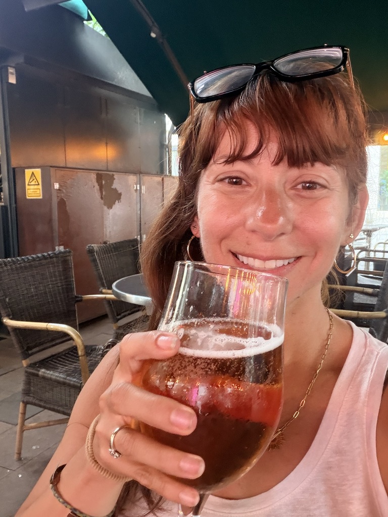 Nicole with a drink at an outdoor cafe table in Copenhagen
