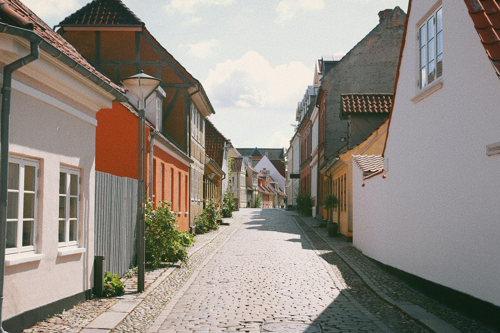 A narrow cobbled lane of painted old houses in Odense on the island of Funen