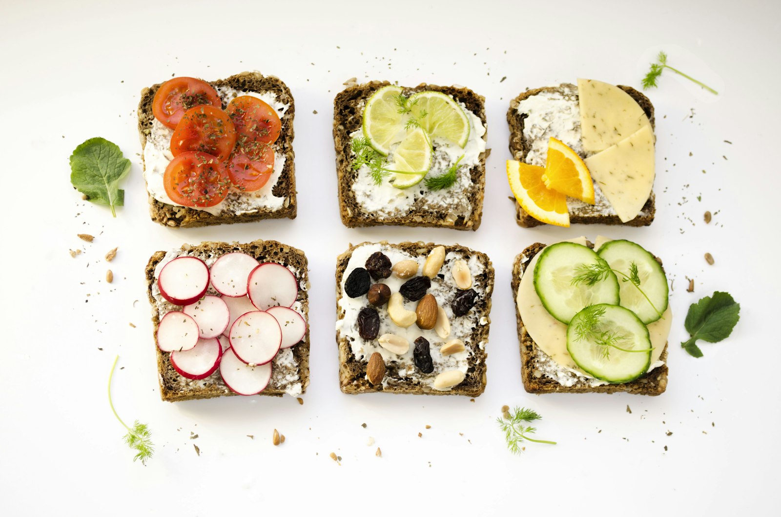 Open faced rye bread sandwiches topped with salmon, egg and cucumber seen from above