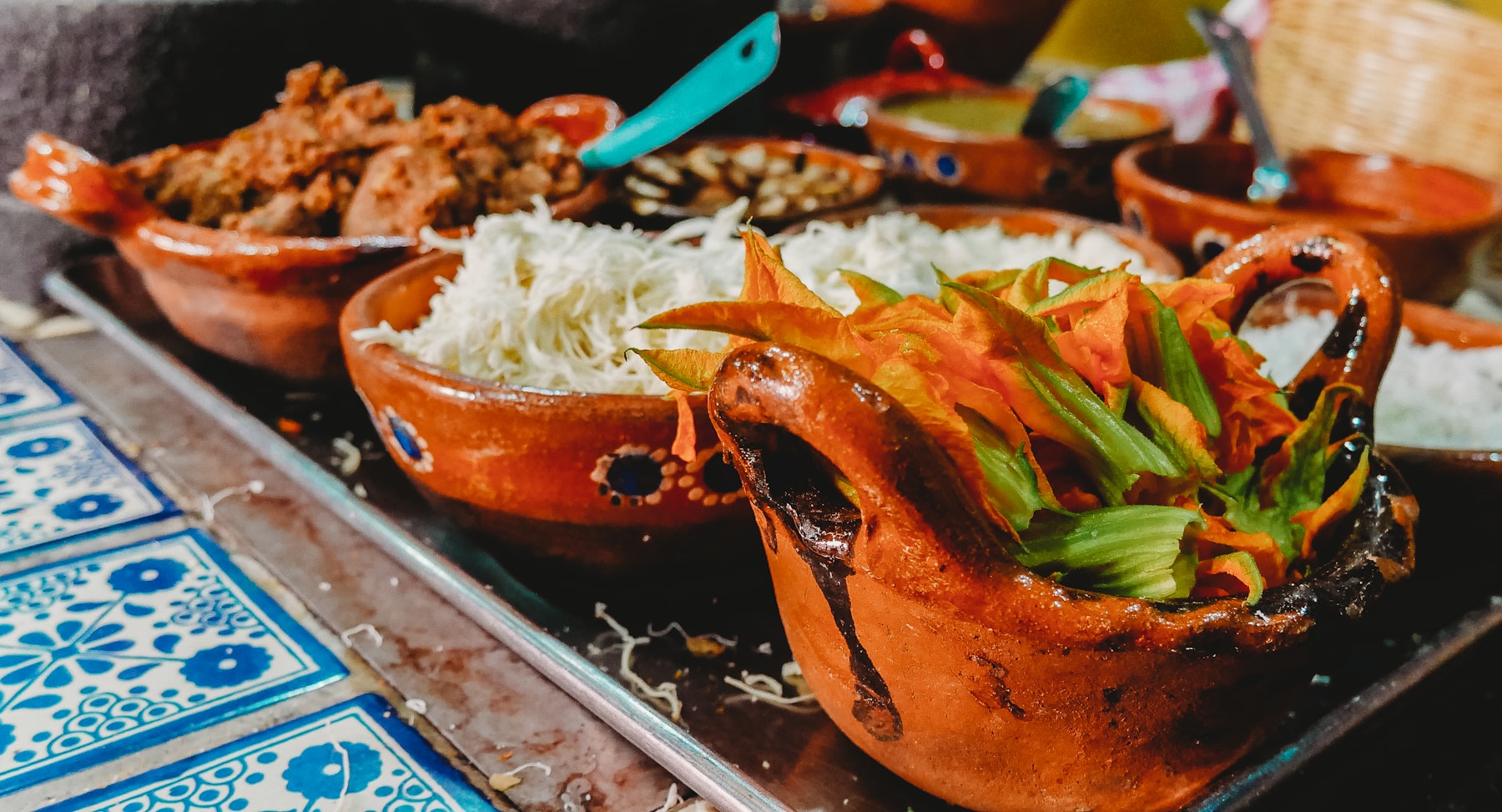 Clay bowls of Ecuadorian stew and rice set out on a tiled table