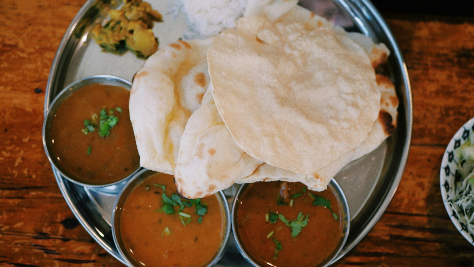 Round roti flatbreads stacked in a tray