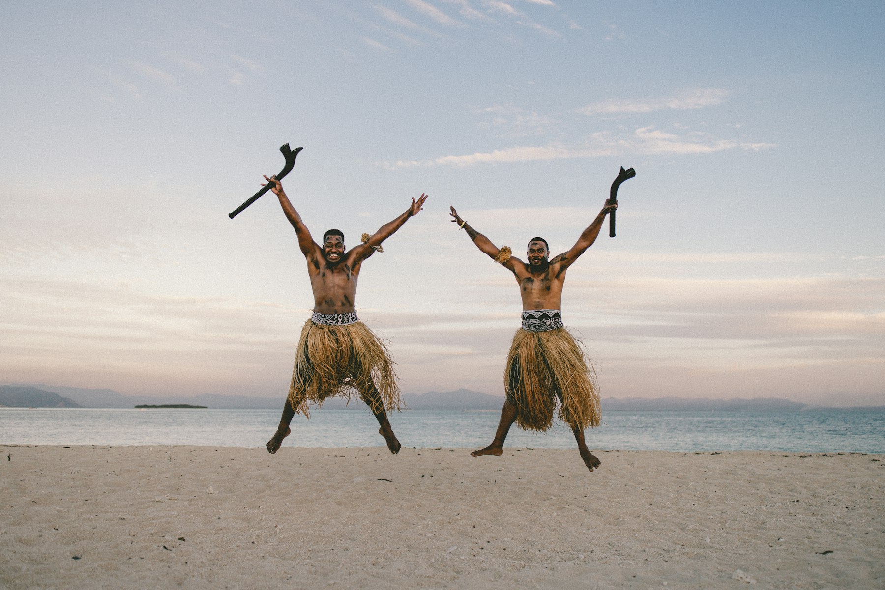 Two Fijian men in traditional dress on the beach at Beachcomber Island in the Mamanuca group of Fiji