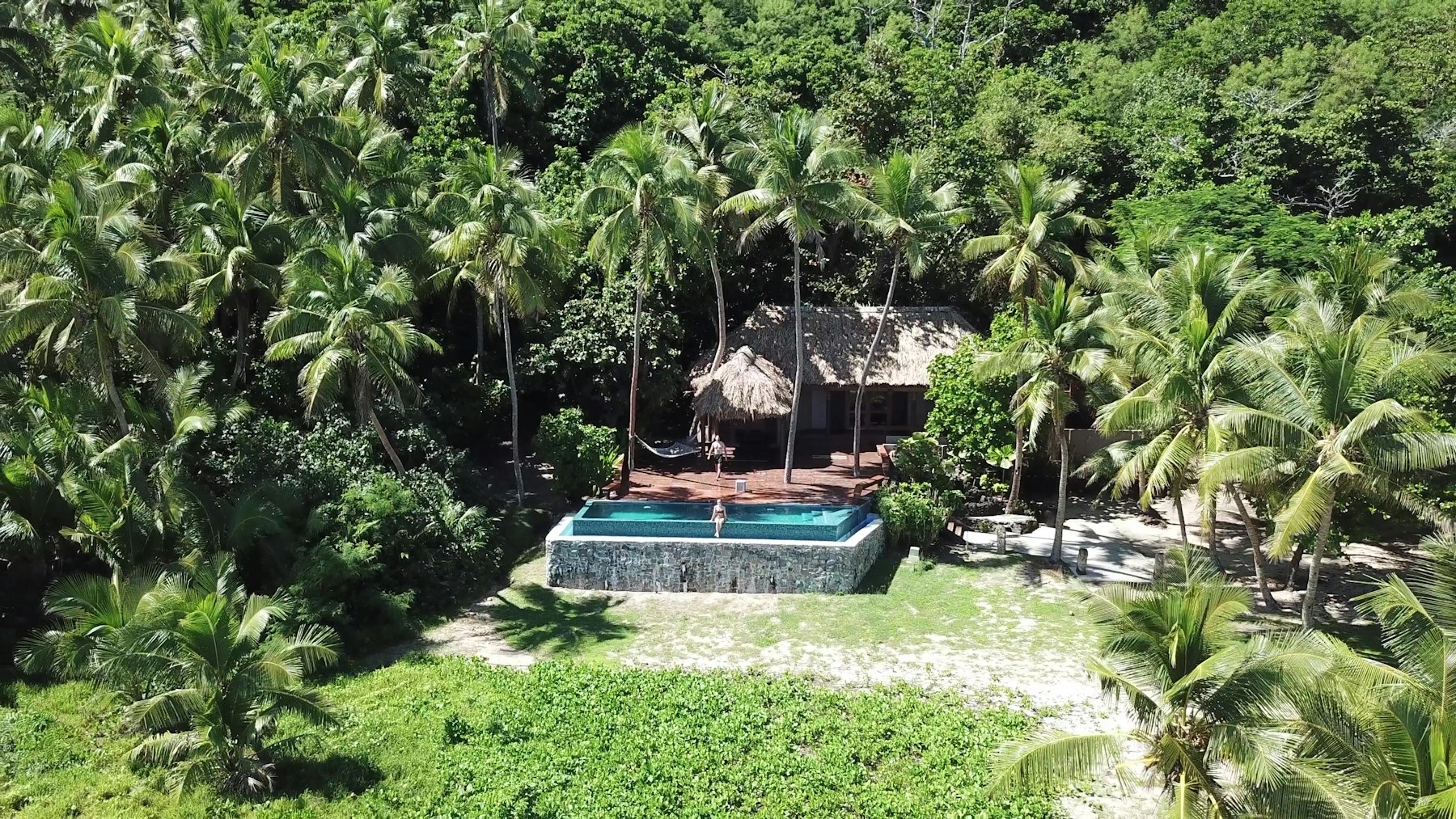 A resort pool among palm trees on Yasawa Island in Fiji