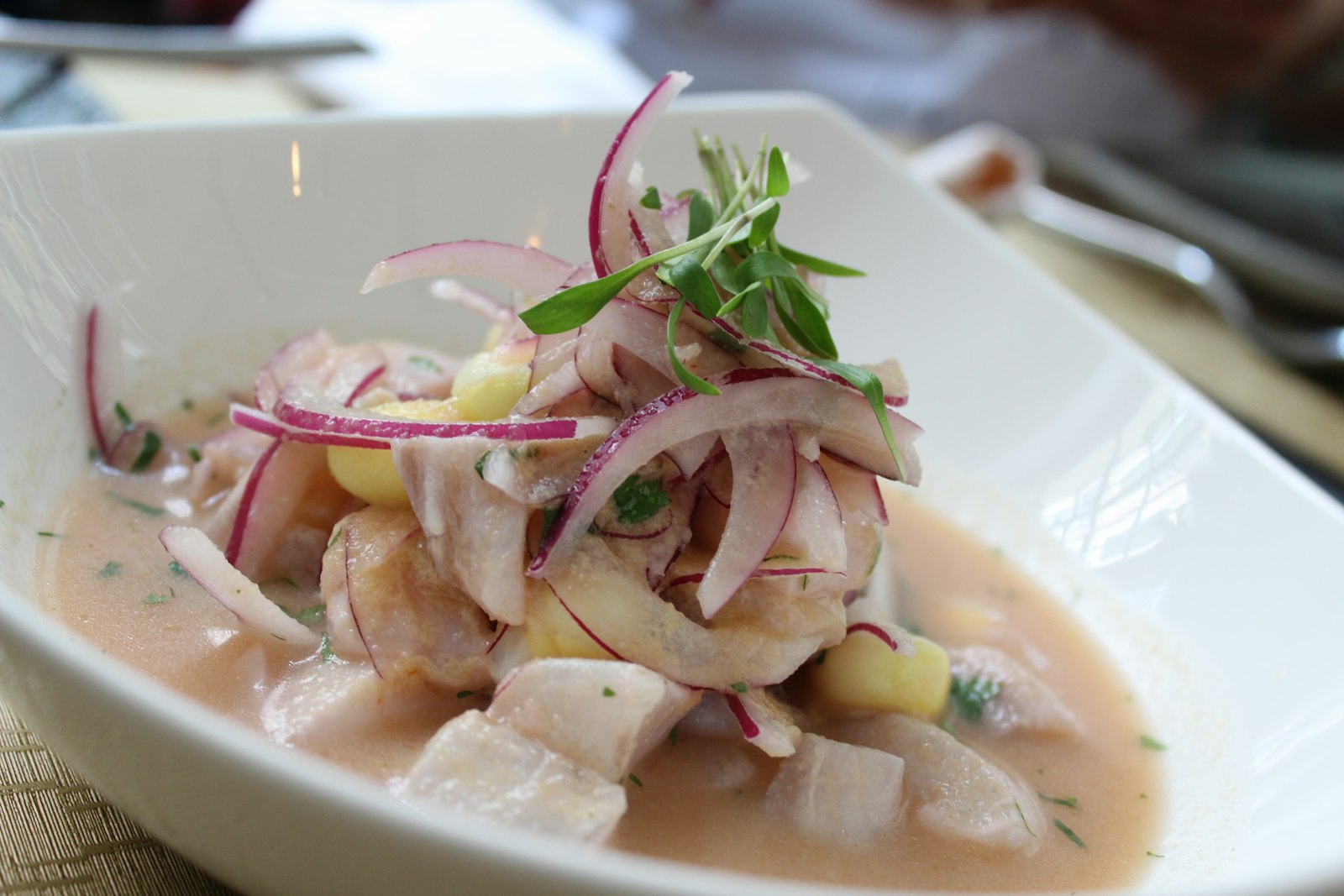 Raw fish cured in lime served in a white bowl