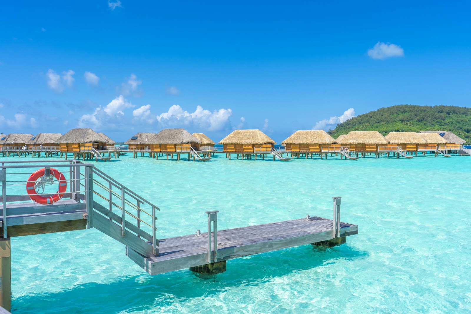 A long wooden dock reaching out over clear water in Bora Bora