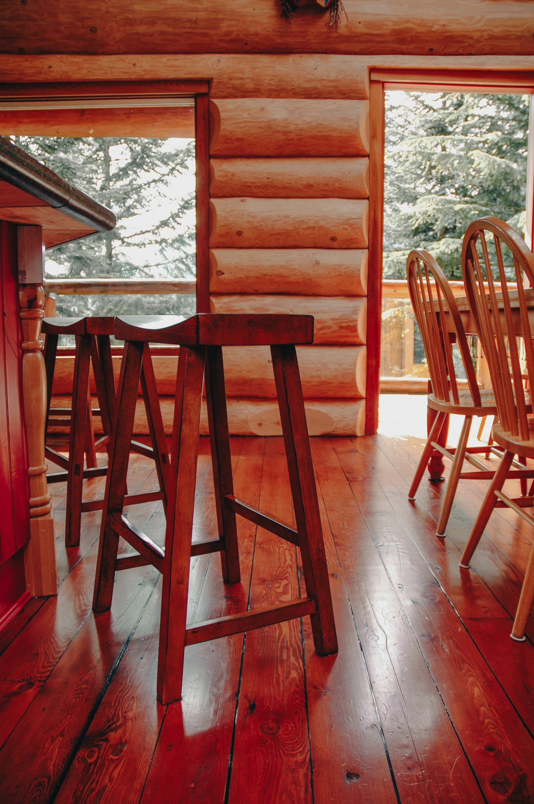 A rustic timber lodge dining room with wooden chairs and tables