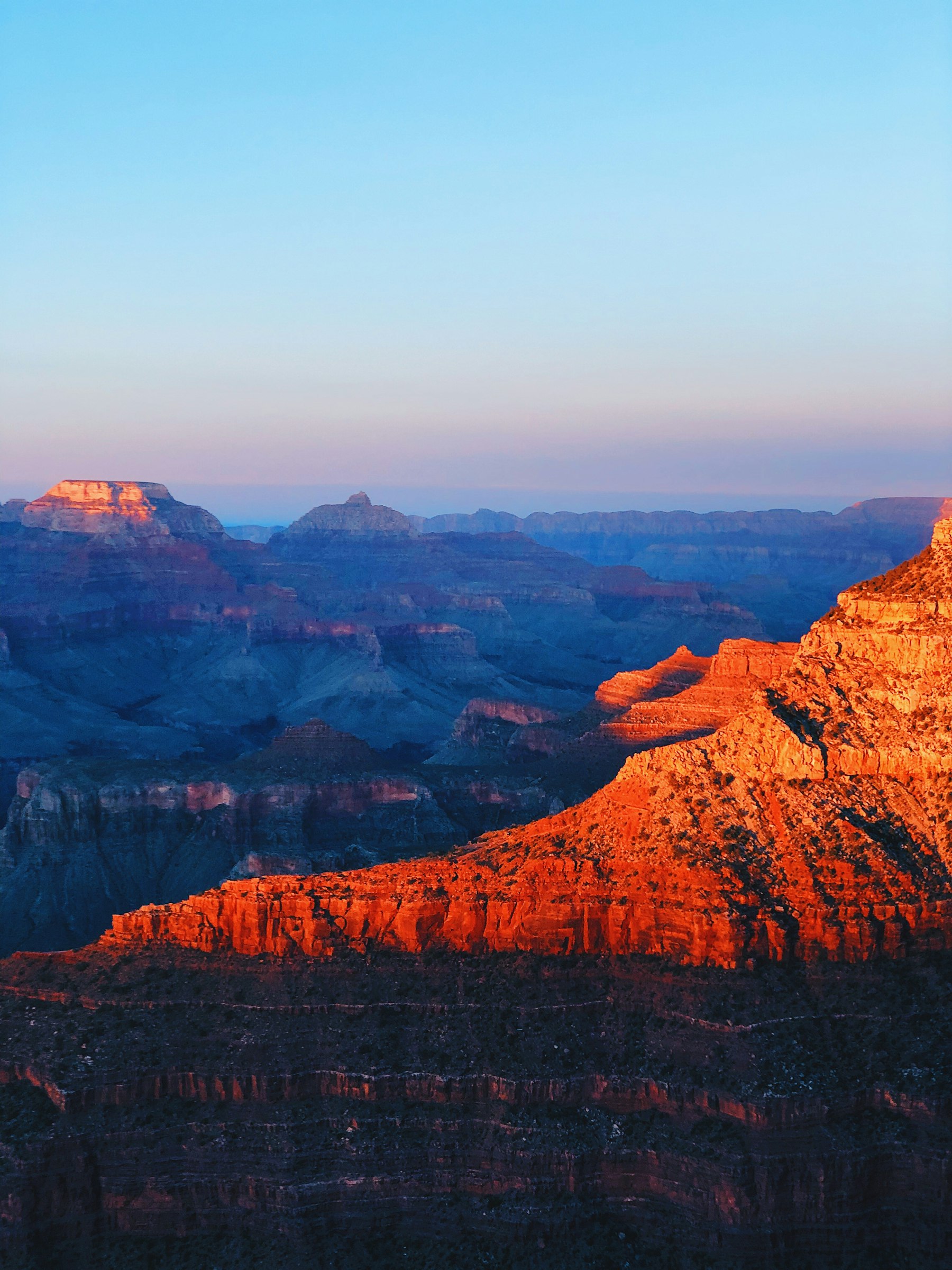 First light striking the red buttes inside the Grand Canyon