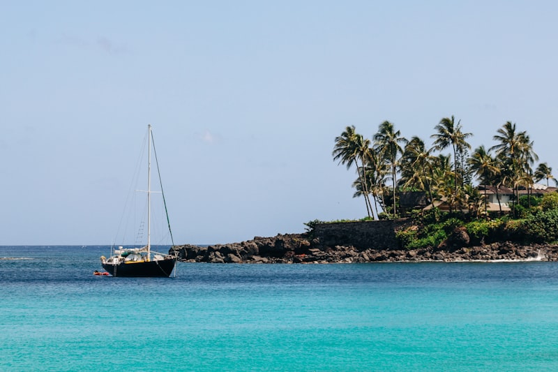 A white sailing boat on flat blue water in the Caribbean