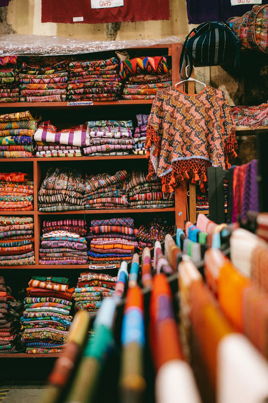 A shop in Antigua Guatemala filled with stacks of woven textiles