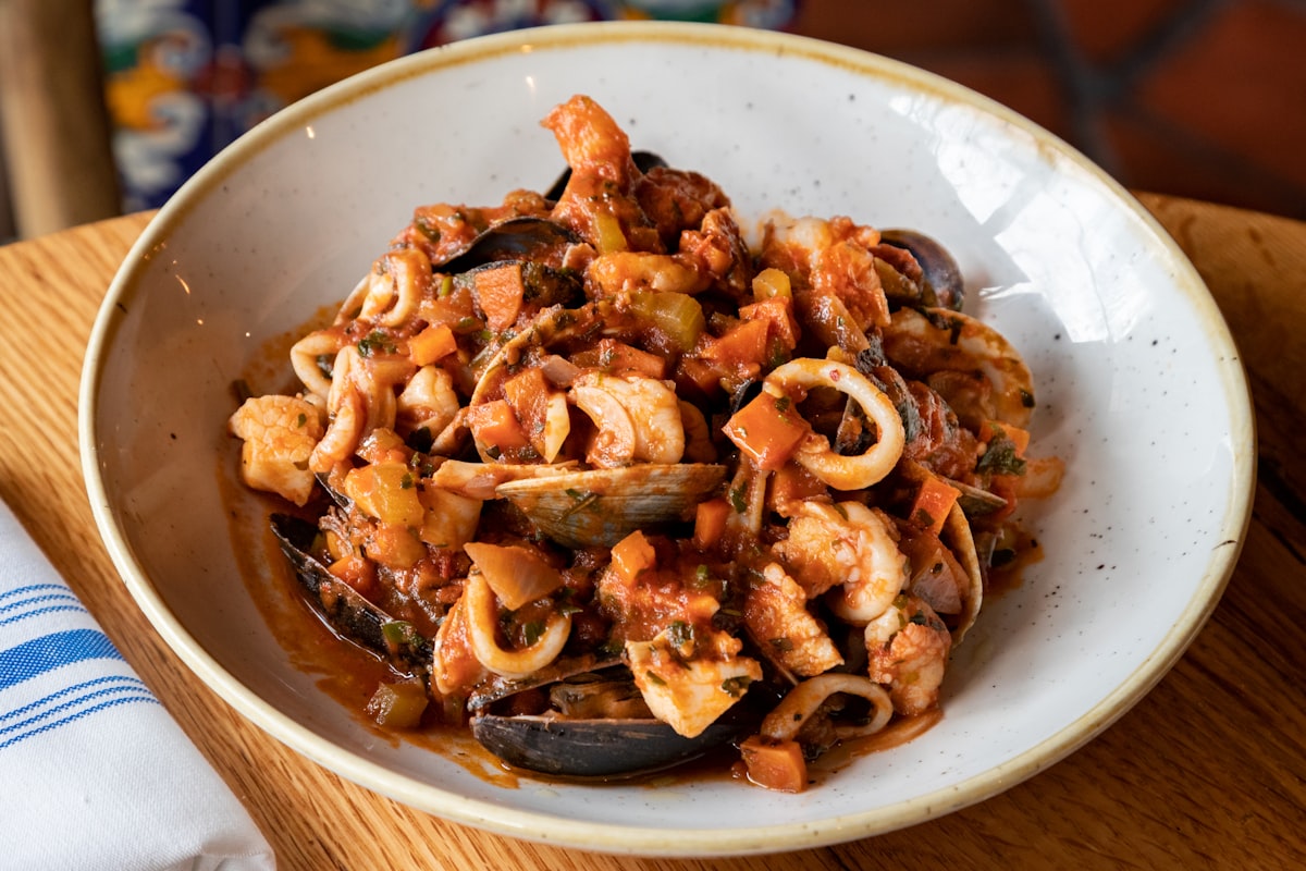 A bowl of shellfish stewed in a tomato and pepper sauce
