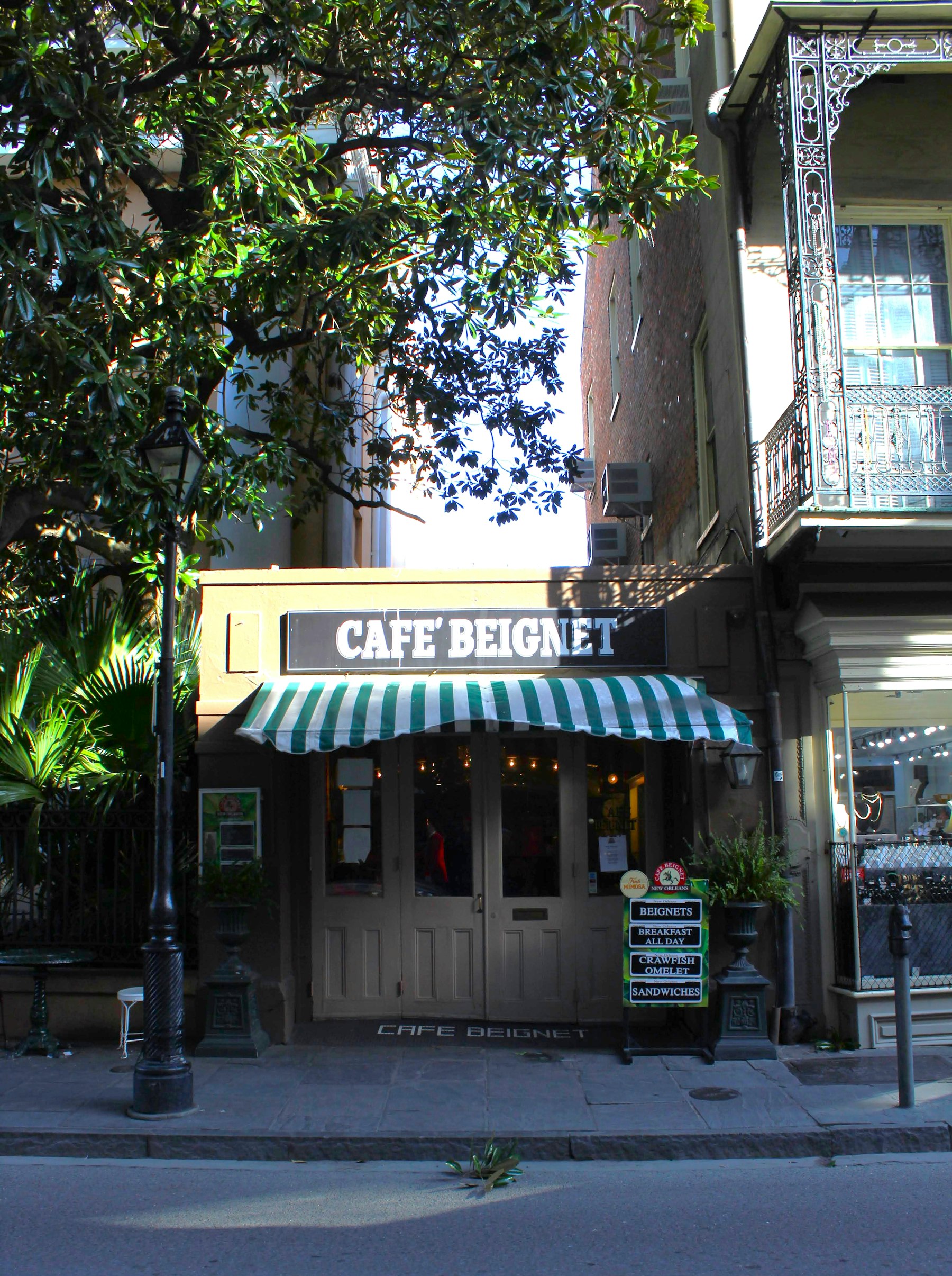 The green and white striped awning of a beignet cafe in the New Orleans French Quarter
