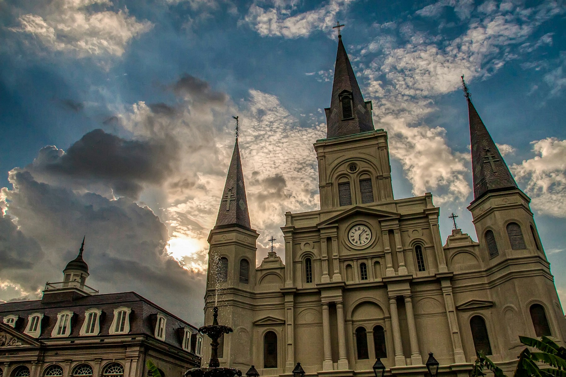 The three spires of St Louis Cathedral in New Orleans against a cloudy sky