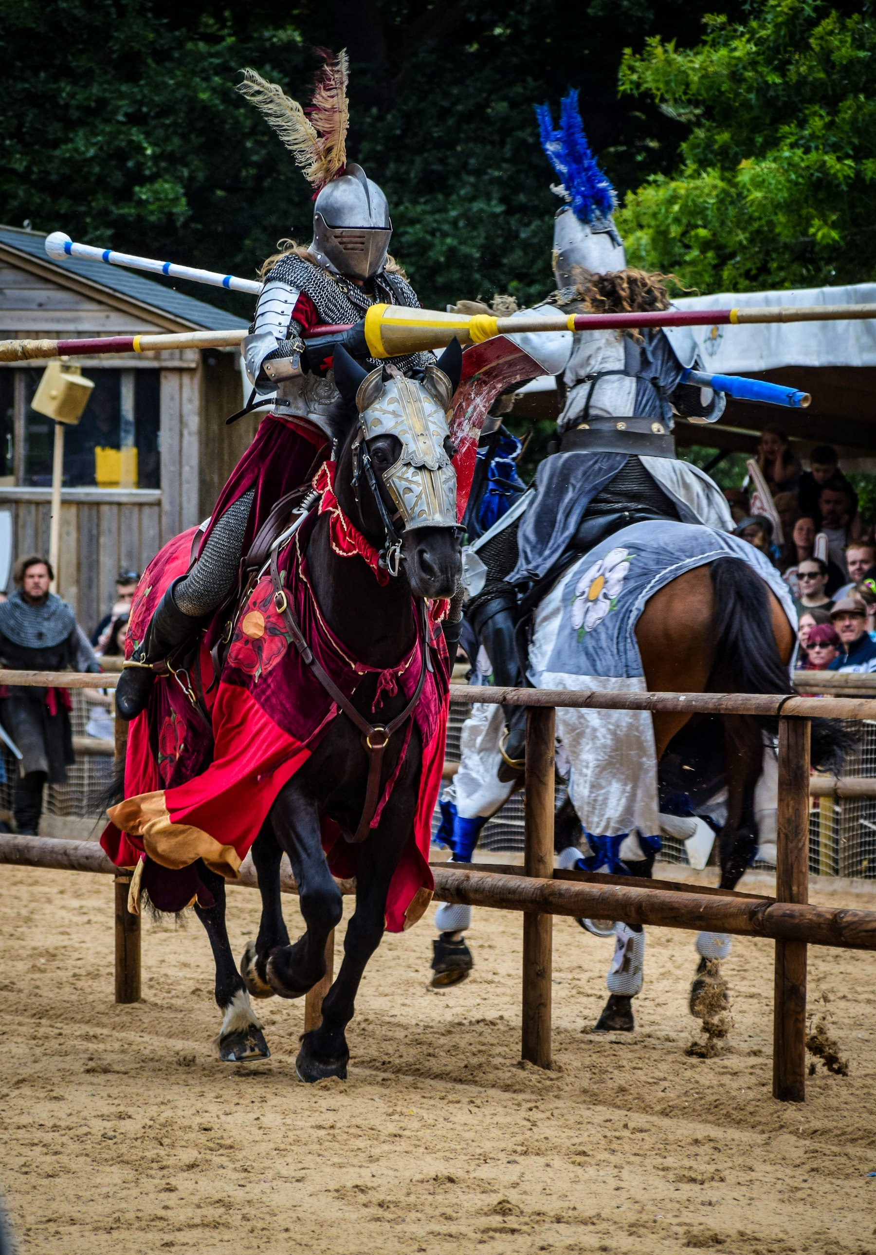 An armoured knight on horseback riding in front of an audience