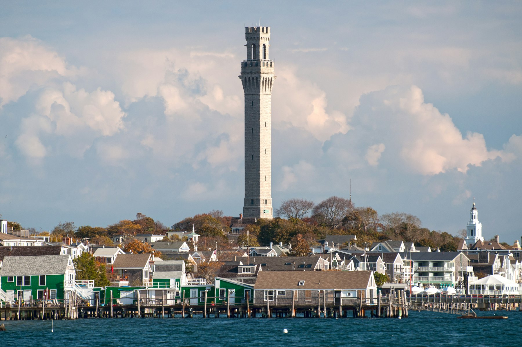 The Pilgrim Monument tower rising above the waterfront houses of Provincetown Massachusetts