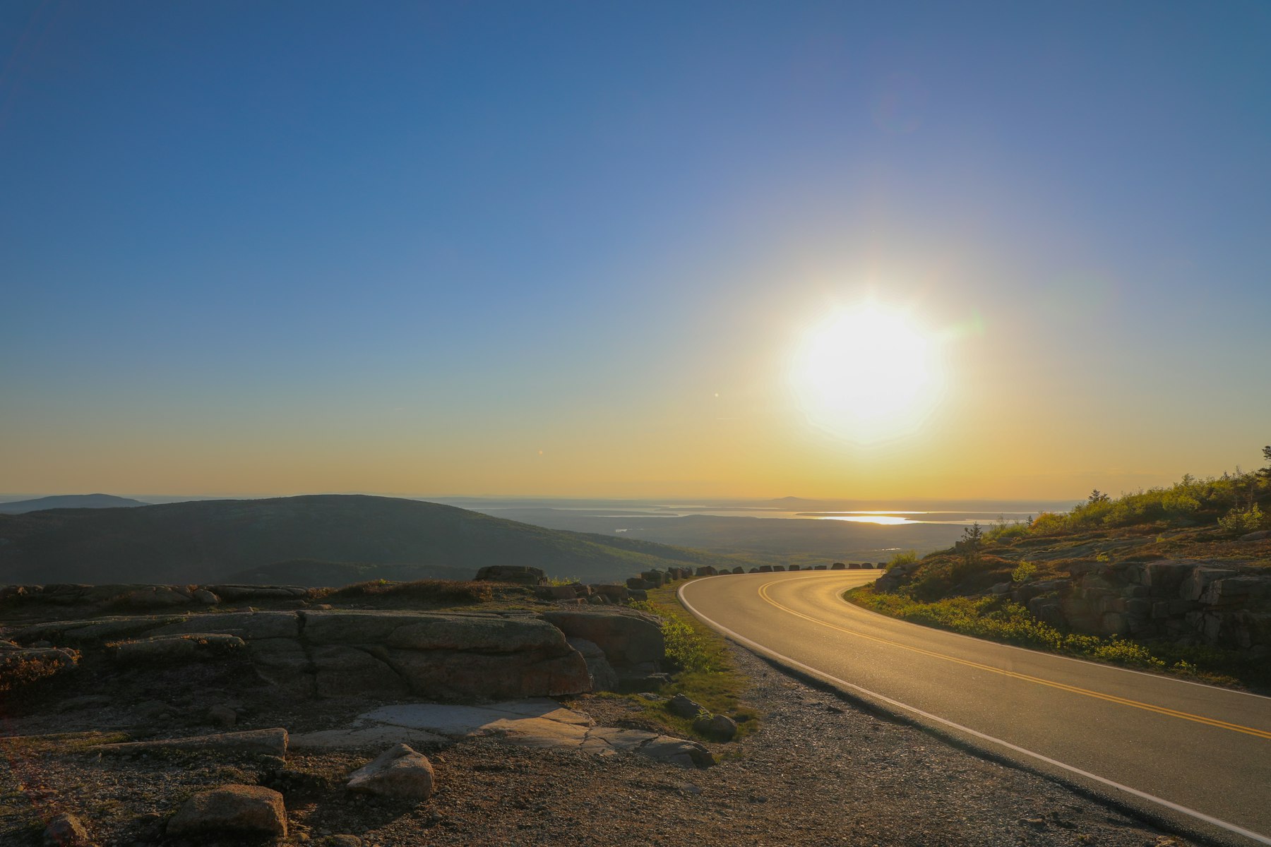 The paved Park Loop Road curving over an open granite ridge in Acadia National Park