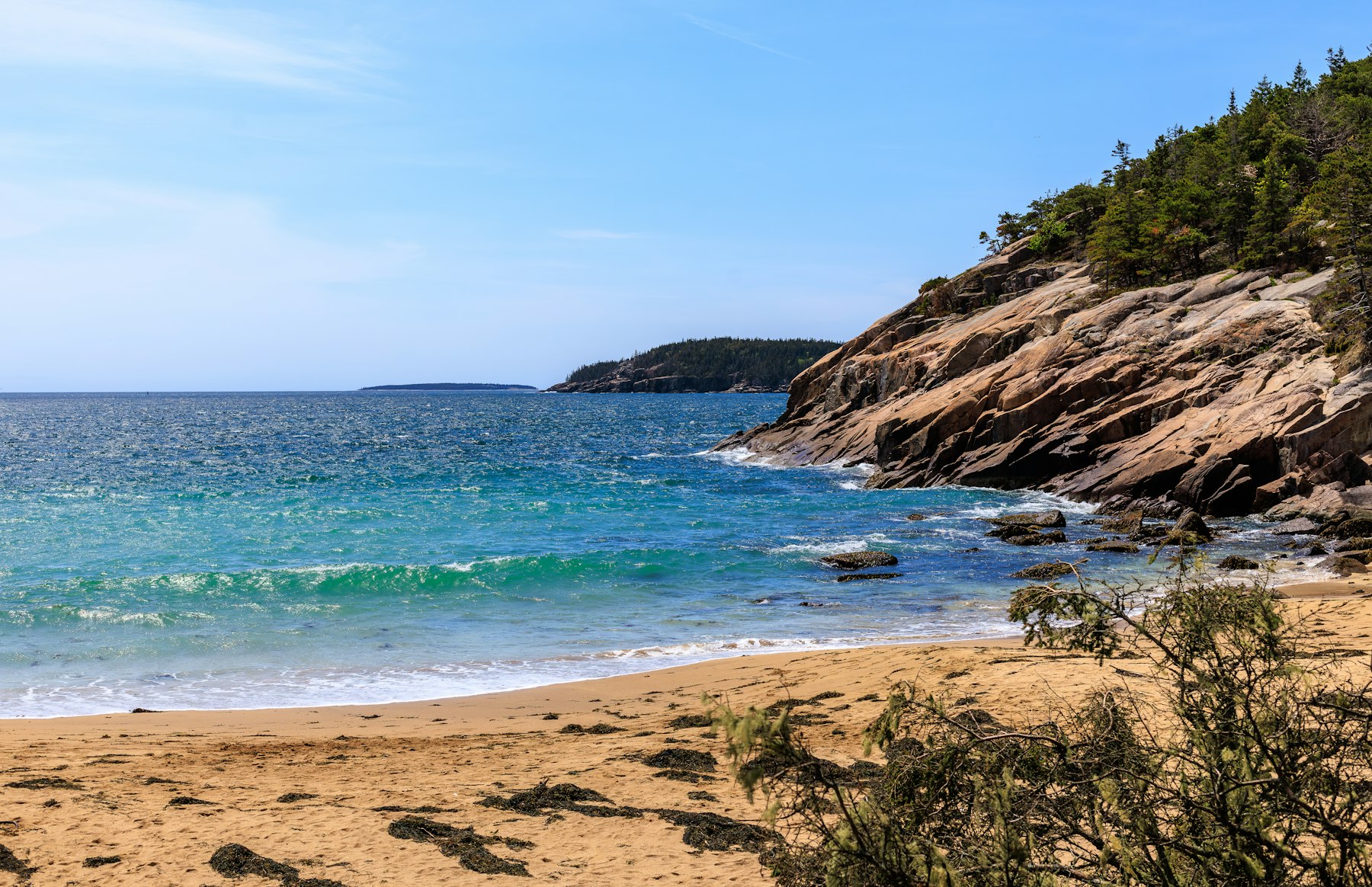 Sand Beach and pink granite cliffs with clear water at Acadia National Park Maine