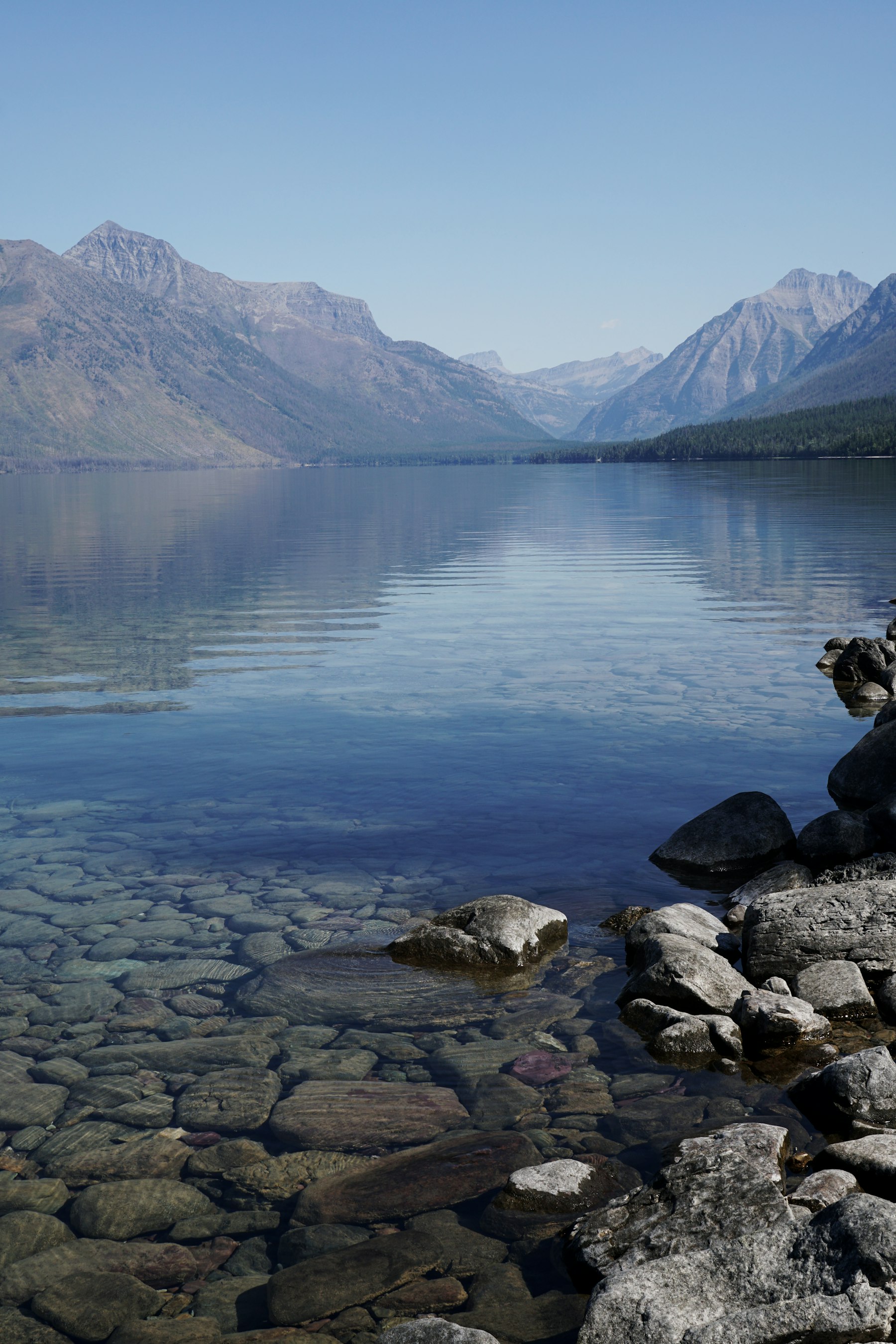 Coloured pebbles under clear shallow water at the edge of Lake McDonald in Montana