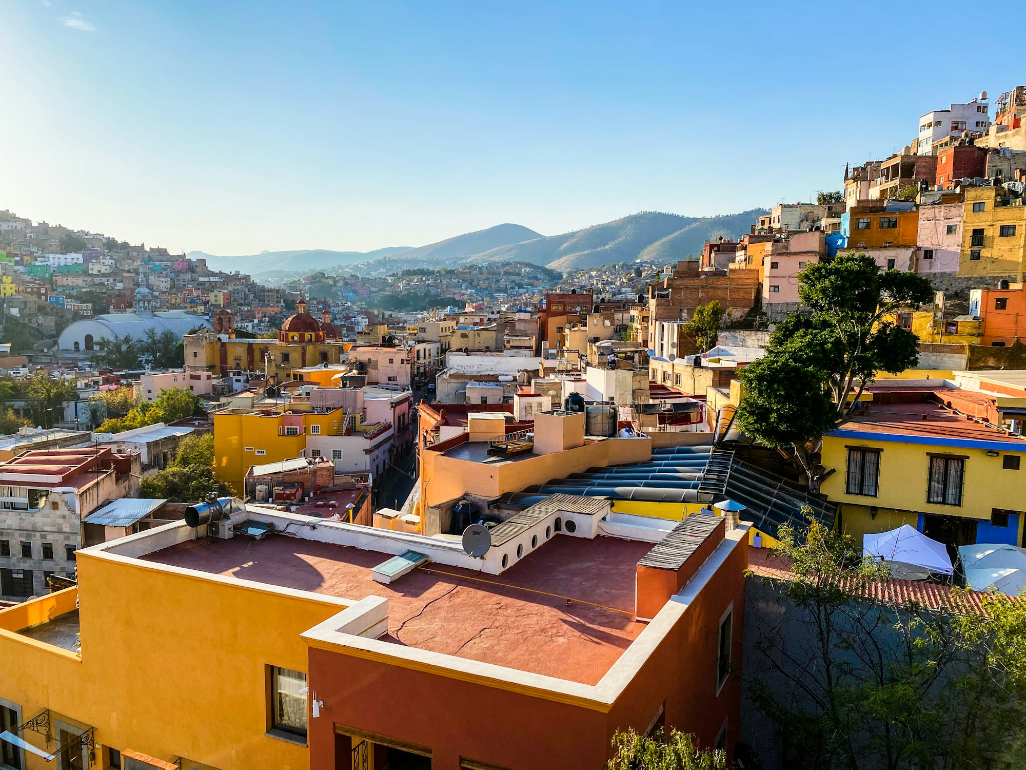 Brightly painted houses stacked up the hillside above the rooftops of Guanajuato