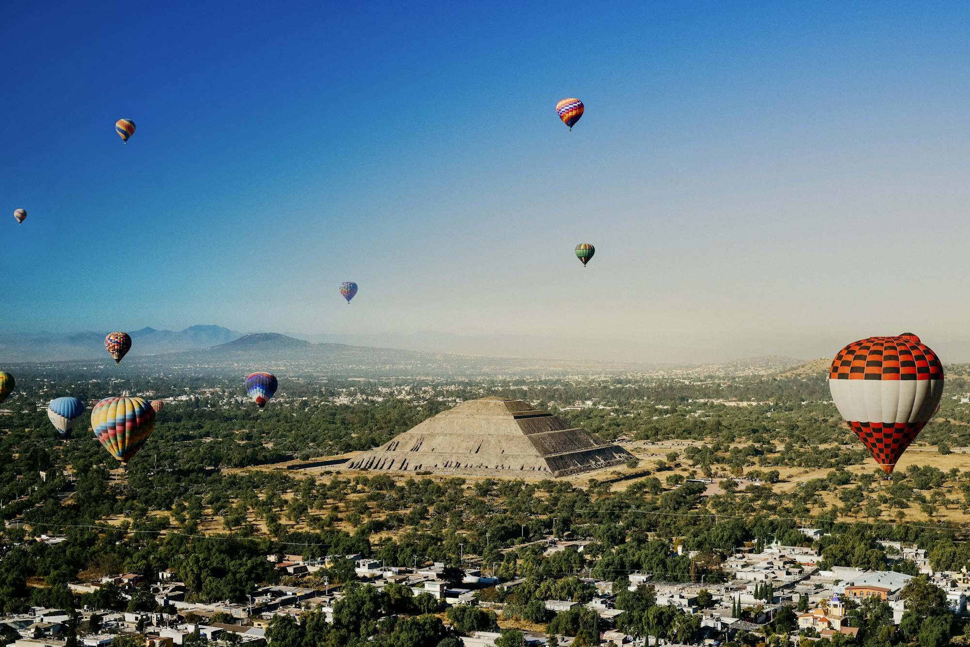 Hot air balloons floating over the Pyramid of the Sun at Teotihuacan at dawn